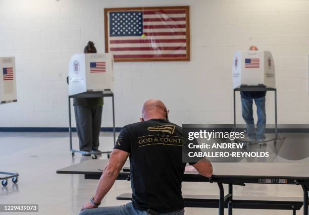 Voters cast their ballots at a polling station, on election day in Leesburg, Virginia on November 3, 2020. The US started voting Tuesday in an...