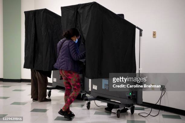 Voter walks up to a voter booth to cast her ballot at the Franklin Institute in Philadelphia on Tuesday, Nov. 3, 2020.