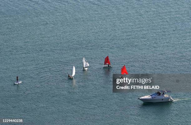 Picture taken on November 3, 2020 shows people on sail boats, stand-up-paddle and a motor boat in the Tunisian village of Sidi Bou Said.