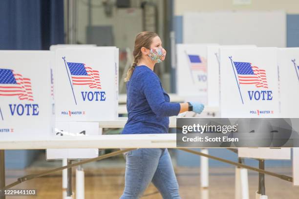 Election worker moves between voting booths at a polling location on November 3, 2020 in Hermon, Maine. After a record-breaking early voting turnout,...