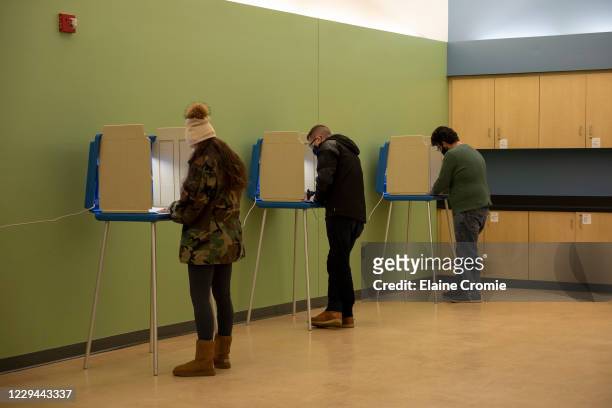 Three people vote inside the Troy Community Center on November 3, 2020 in Troy, Michigan. After a record-breaking early voting turnout, Americans...