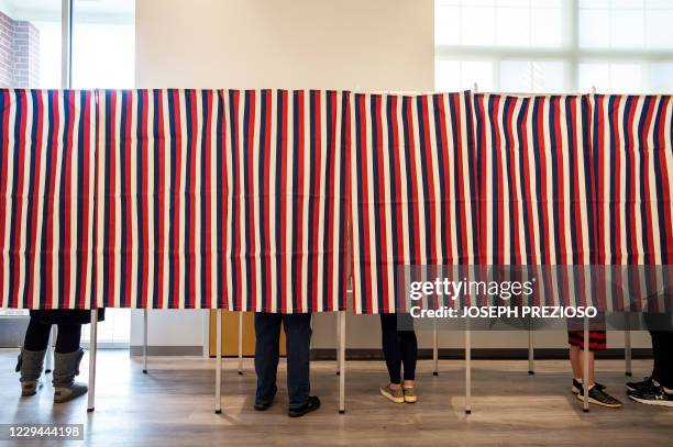 Voters fill in their ballots at polling booths in Concord, New Hampshire, on November 3, 2020. Americans were voting on Tuesday under the shadow of a...