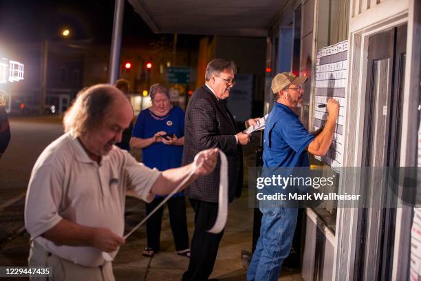 Cairo Messenger newspaper publisher and editor Randy Fine, center, calls out election results as Steve Reagan writes them on the board on the front...