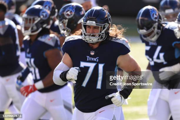 Tennessee Titans offensive tackle Dennis Kelly runs onto the field before the game against the Tennessee Titans and the Cincinnati Bengals on...