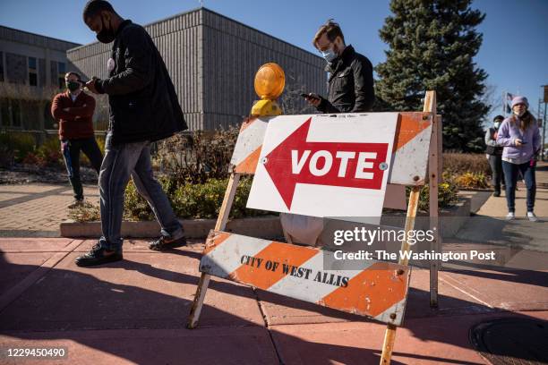 3rd: A line of voters wrap around the sidwalks outside West Allis City Hall, a suburb just to the west of Milwaukee on November 3rd, 2020. Voters...