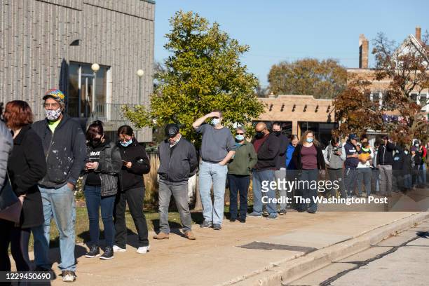 3rd: A line of voters wrap around the sidwalks outside West Allis City Hall, a suburb just to the west of Milwaukee on November 3rd, 2020. Voters...