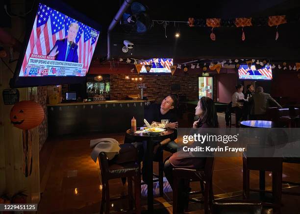 Customers watch a speech by U.S. President Donald Trump on a television during an election watching event at a local bar on November 4, 2020 in...