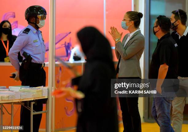 An Emirati policeman uses a smart helmet to detect people's temperature as a tool to fight the spread of the Covid-19 coronavirus among the visitors...