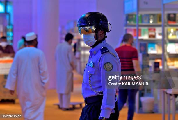 An Emirati policeman uses a smart helmet to detect people's temperature as a tool to fight the spread of the Covid-19 coronavirus among the visitors...