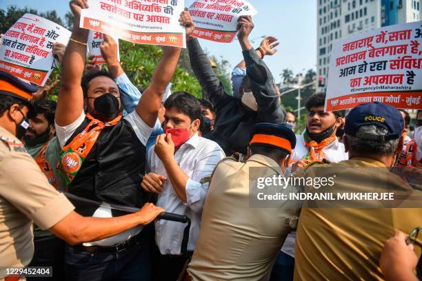 Activists and supporters of Bharatiya Janata Party hold placards as they scuffle with police while protesting against the arrest of Indian television...