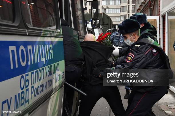 Police officers detain a participant of a nationalists rally in downtown Moscow on November 4, 2020. - Activists were detained on their way to the...