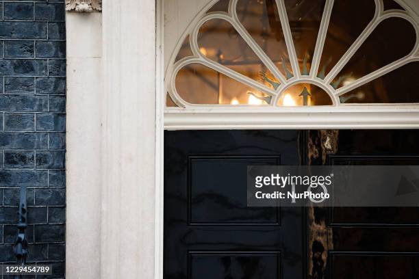 Lights shine behind the door of 10 Downing Street in London, England, on November 4, 2020.