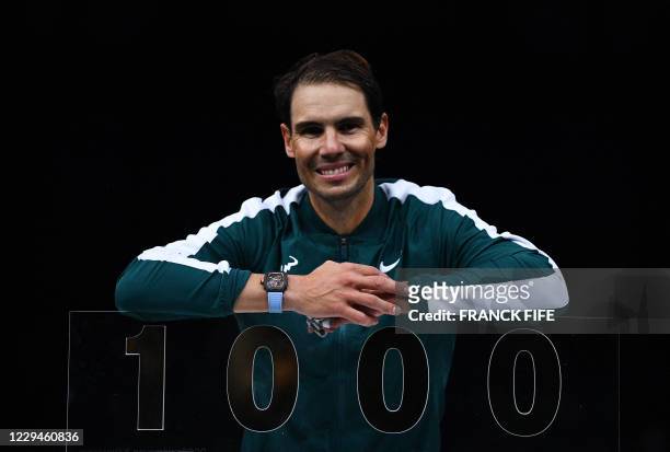 Spain's Rafael Nadal poses with the trophy of his one thousandth victory of the ATP at the end of his men's singles second round tennis match against...