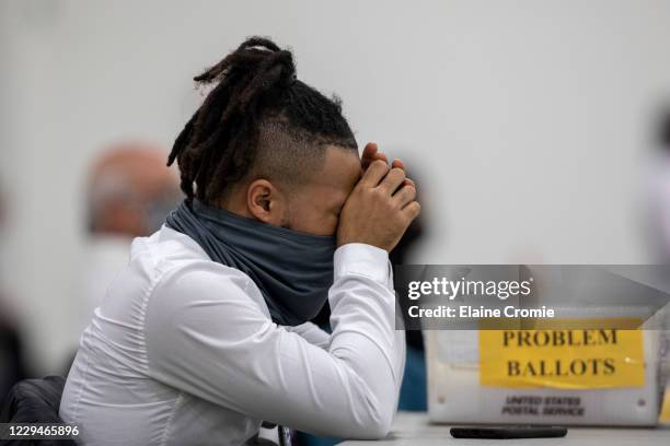 Worker with the Detroit Department of Elections takes a break after sorting through absentee ballots at the Central Counting Board in the TCF Center...