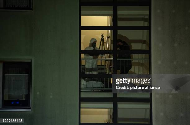 November 2020, Berlin: Forensic technicians work in a stairwell of an apartment building in the Plänterwald district . A three-year-old girl has been...