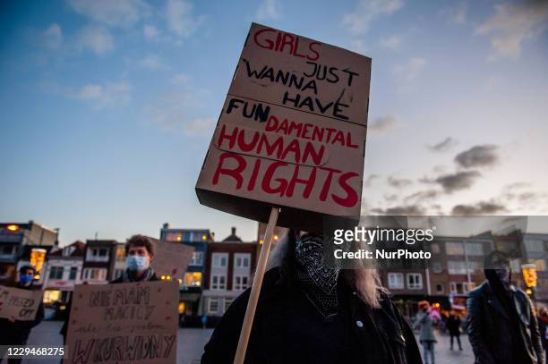 Woman is using a big placard to cover her face, during a peaceful demonstration in solidarity with Polish women, in Nijmegen, on November 4th, 2020.