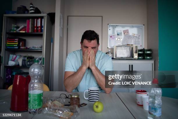 Medical worker yawns as he takes a break at the intensive care unit for patients infected by Covid-19 of the university-affiliated hospital Cavale...