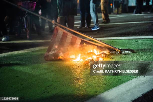 Protesters burn a US flag in Portland, Oregon on November 4 during a demonstration called by the "Black Lives Matter" movement, a day after the US...