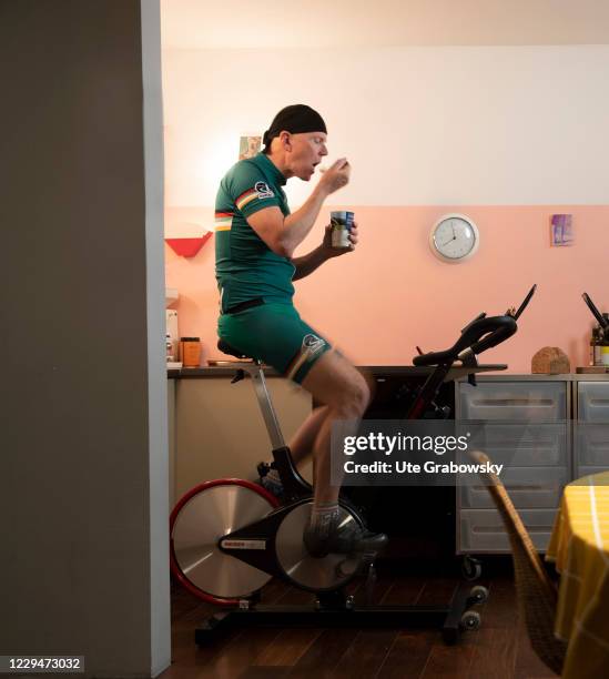 In this photo illustration a man on exercise bike in a kitchen is having a meal on November 04, 2020 in Bonn, Germany.