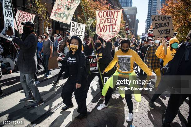 Demonstrators wearing protective masks dance at a protest in front of the Convention Center during the 2020 Presidential election in Philadelphia,...