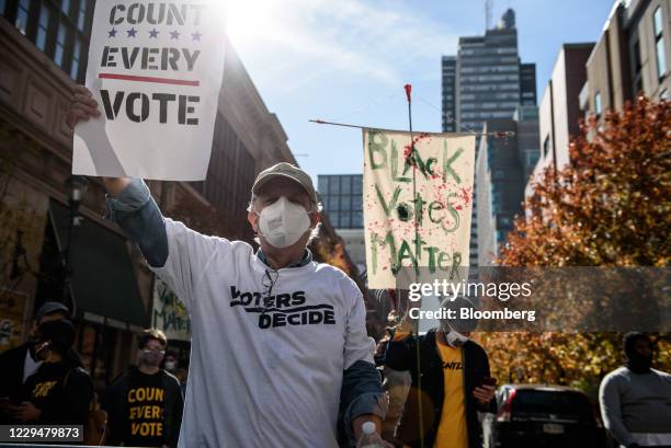 Demonstrator wearing a protective mask holds a "Count Every Vote" sign at a protest in front of the Convention Center during the 2020 Presidential...
