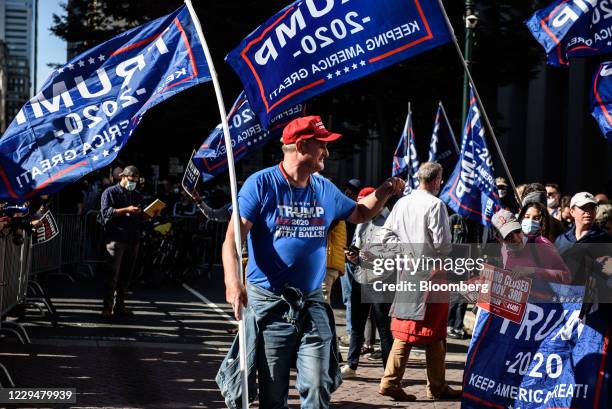 Supporters of U.S. President Donald Trump holds flags while rallying in front of the Convention Center during the 2020 Presidential election in...