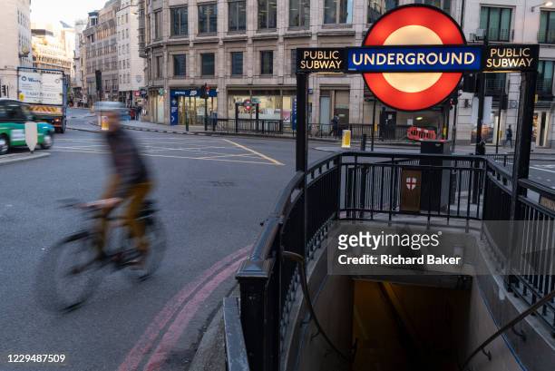 On the first day of the government's second national Coronavirus lockdown, a cyclist passes an entrance to Monument underground station in the...
