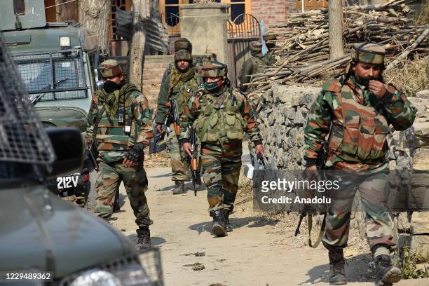 Indian army soldiers walk near the site of gun-battle in Meej area of Pampore in south Kashmir on November 06, 2020. Two militants and a civilian...