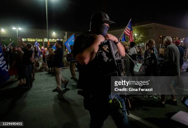 Gun toting Trump supporter who would only give his last name, Alan of Mesa, attends a protest in the parking lot at the Maricopa County Tabulation...