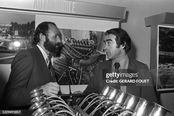 Le directeur général de Matra, Jean-Luc Lagardère discute le 10 décembre 1974, à Velizy, avec le coureur automobile Henri Pescarolo devant un moteur...