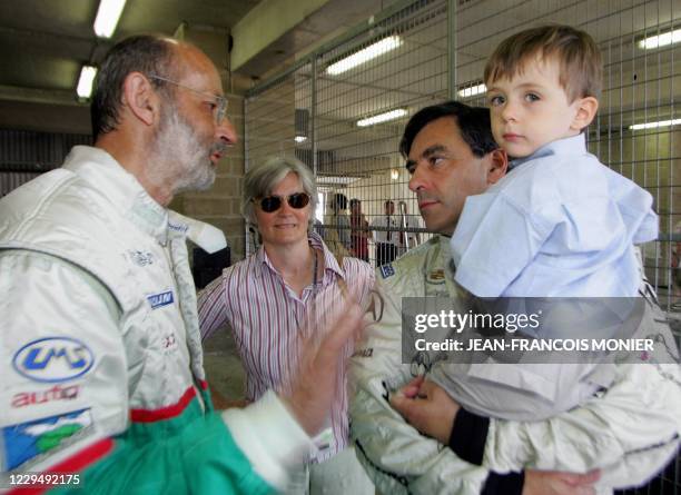 Le ministre de l'Education nationale , François Fillon, avec son fils Arnaud dans les bras, écoute Henri Pescarolo , quintuple vainqueur des 24...