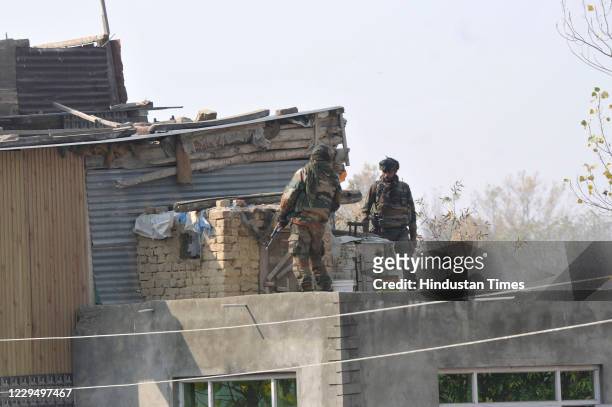 Army soldiers search a house for an escaped militant near the site of a gunfight in Meej village, Pampore on November 6, 2020 in Pulwama, India. Two...
