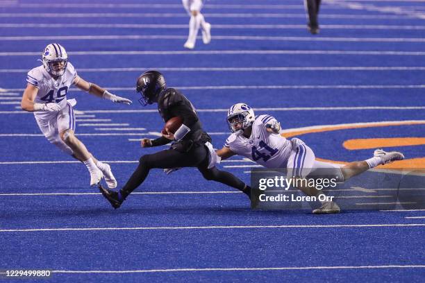 Quarterback Andy Peters of the Boise State Broncos scrambles away from the tackle of linebacker Keenan Pili of the BYU Cougars during second half...