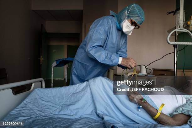 Medical worker provides care to a patient infected with Covid-19 disease caused by the novel coronavirus in the Covid-19 unit of the "Hopital Prive...