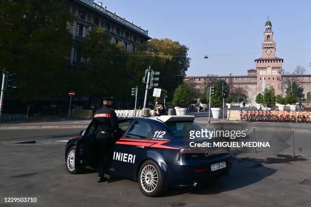 Carabinieri officers wearing protective masks stand in front of the Sforza castle in the center of Milano on November 7, 2020. - The new measures to...