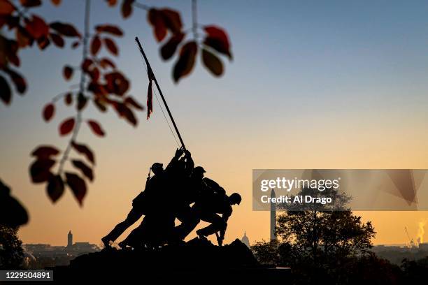 The U.S. Marine Corp's Iwo Jima Memorial can be seen as the morning sun begins to rise behind the U.S. Capitol and Washington Monument on November 7,...