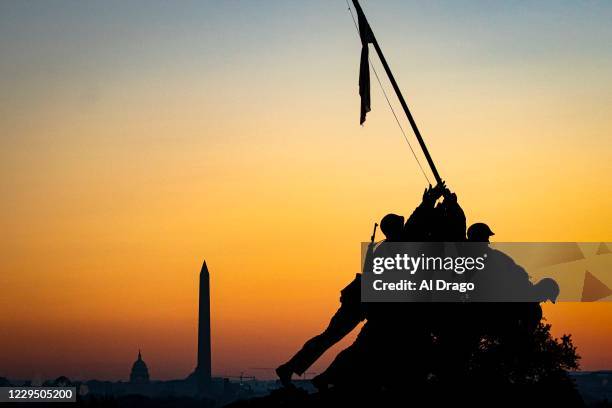 The U.S. Marine Corp's Iwo Jima Memorial can be seen as the morning sun begins to rise behind the U.S. Capitol and Washington Monument on November 7,...