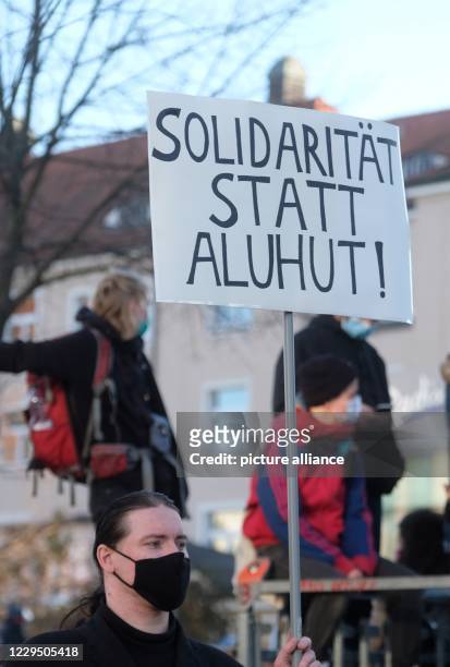 November 2020, Saxony, Leipzig: "Solidarity instead of Aluhut" is written on the sign of a participant of the demonstration against the rally of the...