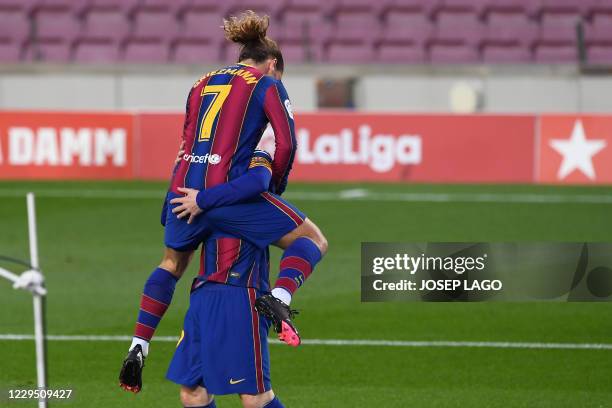 Barcelona's French midfielder Antoine Griezmann celebrates his goal with Barcelona's Argentine forward Lionel Messi during the Spanish League...