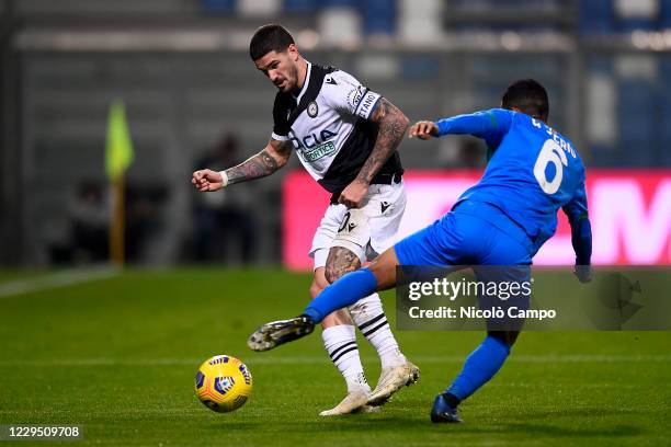 Rodrigo de Paul of Udinese Calcio is challenged by Rogerio Oliveira da Silva of US Sassuolo during the Serie A football match between US Sassuolo and...