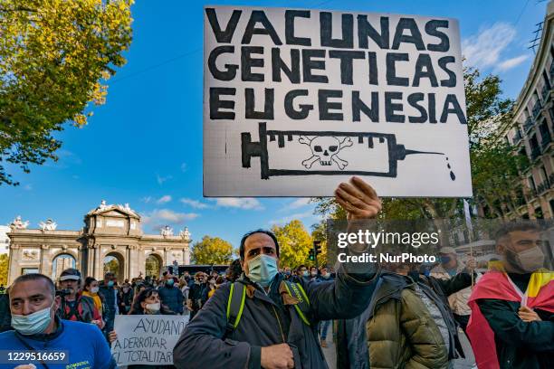Covid-19 denialist holds a banner saying &quot;genetic vaccines, eugenics&quot; during a demonstration in Madrid, Spain, on November 7, 2020 against...