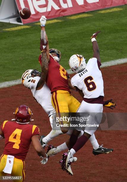 Trojans wide receiver Amon-Ra St. Brown leaps for a deflected ball in the end zone over Arizona State Sun Devils defensive backs DeAndrre Pierce and...