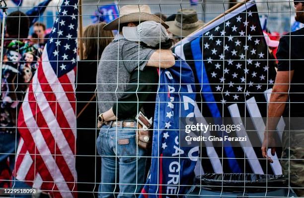 Trump supporters hug hours after Joe Biden was named president-elect during a pro-Trump rally to defy the election outside the Maricopa County...