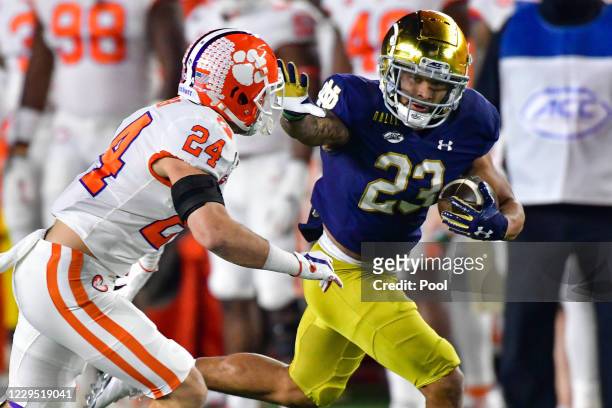 Running back Kyren Williams of the Notre Dame Fighting Irish stiff arms safety Nolan Turner of the Clemson Tigers on his way to a touchdown in the...