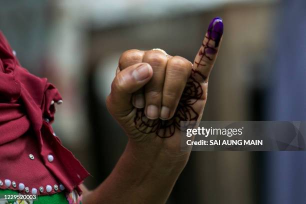 Voter shows an ink-marked finger after casting her ballot at a polling station in Yangon on November 8, 2020.