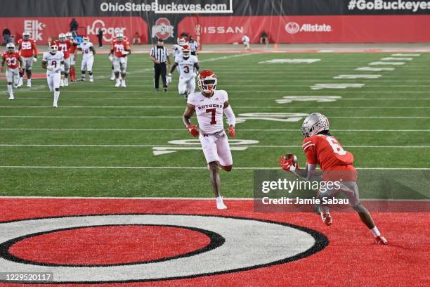 Jameson Williams of the Ohio State Buckeyes catches a 38-yard touchdown pass in the first quarter as Brendon White of the Rutgers Scarlet Knights...