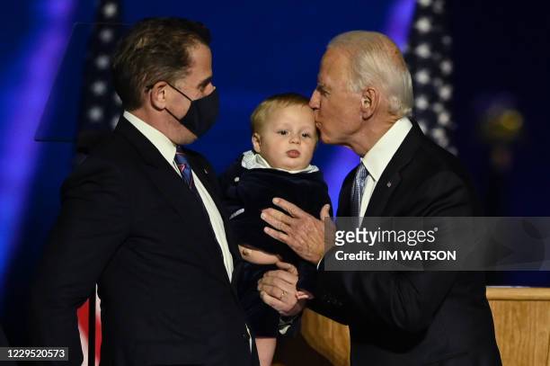 President-elect Joe Biden kisses his grandson held by son Hunter Biden after delivering remarks in Wilmington, Delaware, on November 7 after being...