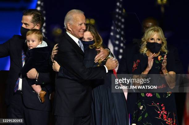 President-elect Joe Biden hugs one of his granddaughters as he stands with grandson and son Hunter Biden, wife Jill Biden after delivering remarks in...