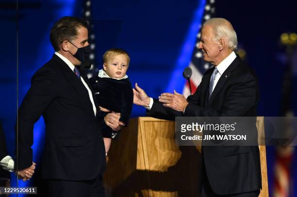 President-elect Joe Biden stands with grandson and son Hunter Biden after delivering remarks in Wilmington, Delaware, on November 7 after being...