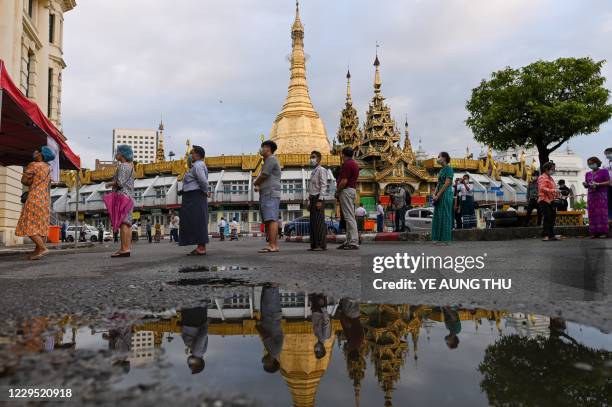 People wait to vote at a polling station next to a Buddhist temple in Yangon on November 8, 2020.